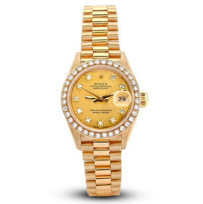 Gold wristwatch with diamond-studded bezel on a white background